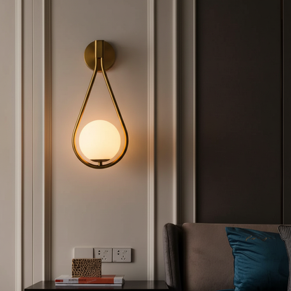 LifeHub Orion gold teardrop wall sconce glowing warmly in luxury living room